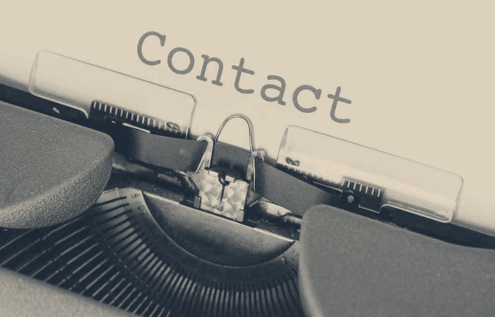 A typewriter with the word Contact typed on the paper